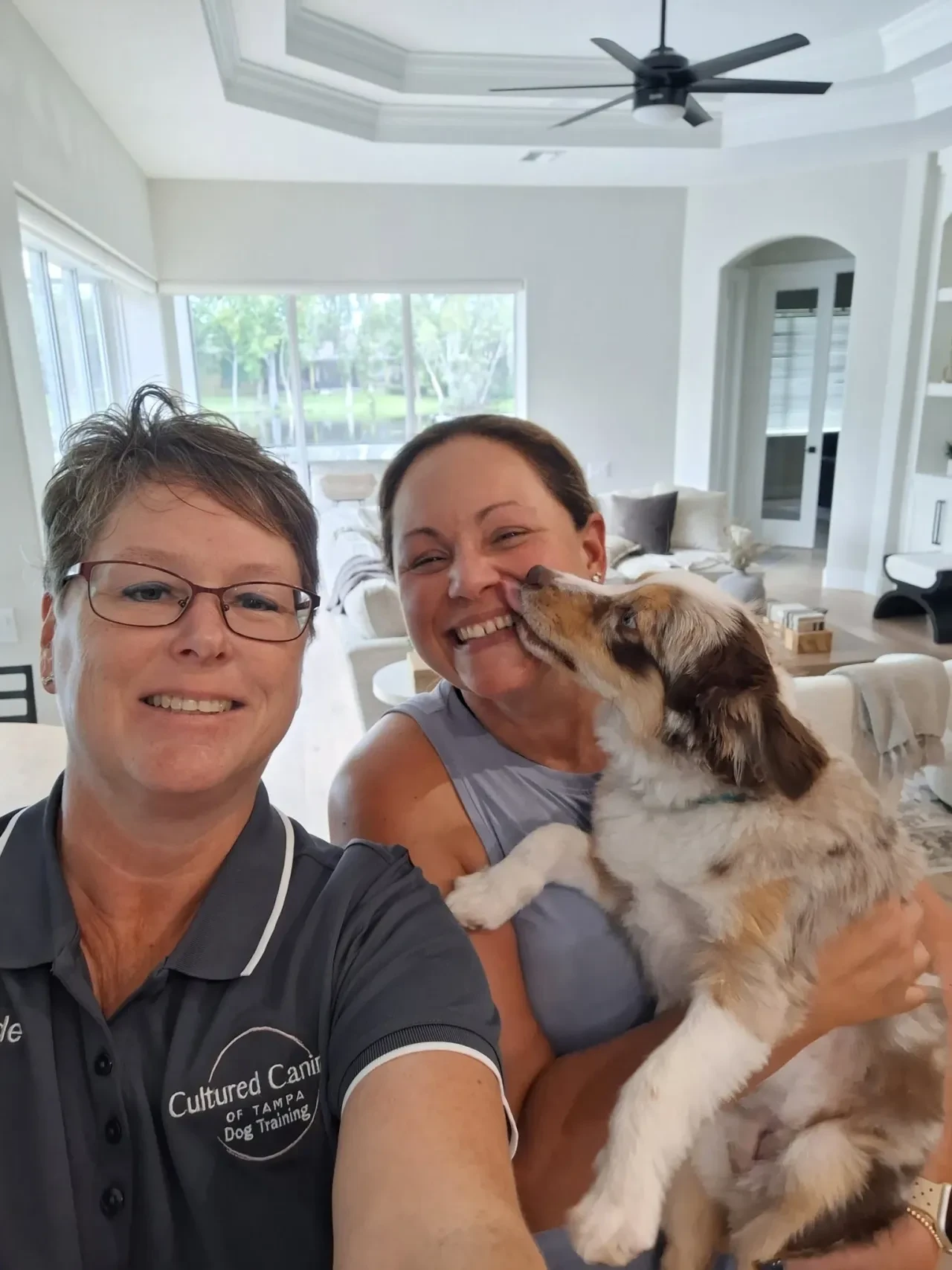 Heide with a smiling client and her Australian Shepherd puppy