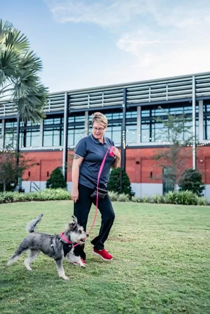 Heide walking a schnauzer on a loose leash through a Tampa park